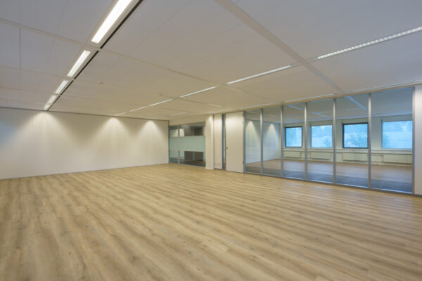 Leeg modern kantoor met glazen scheidingswand aan de Baarnsche Dijk.
